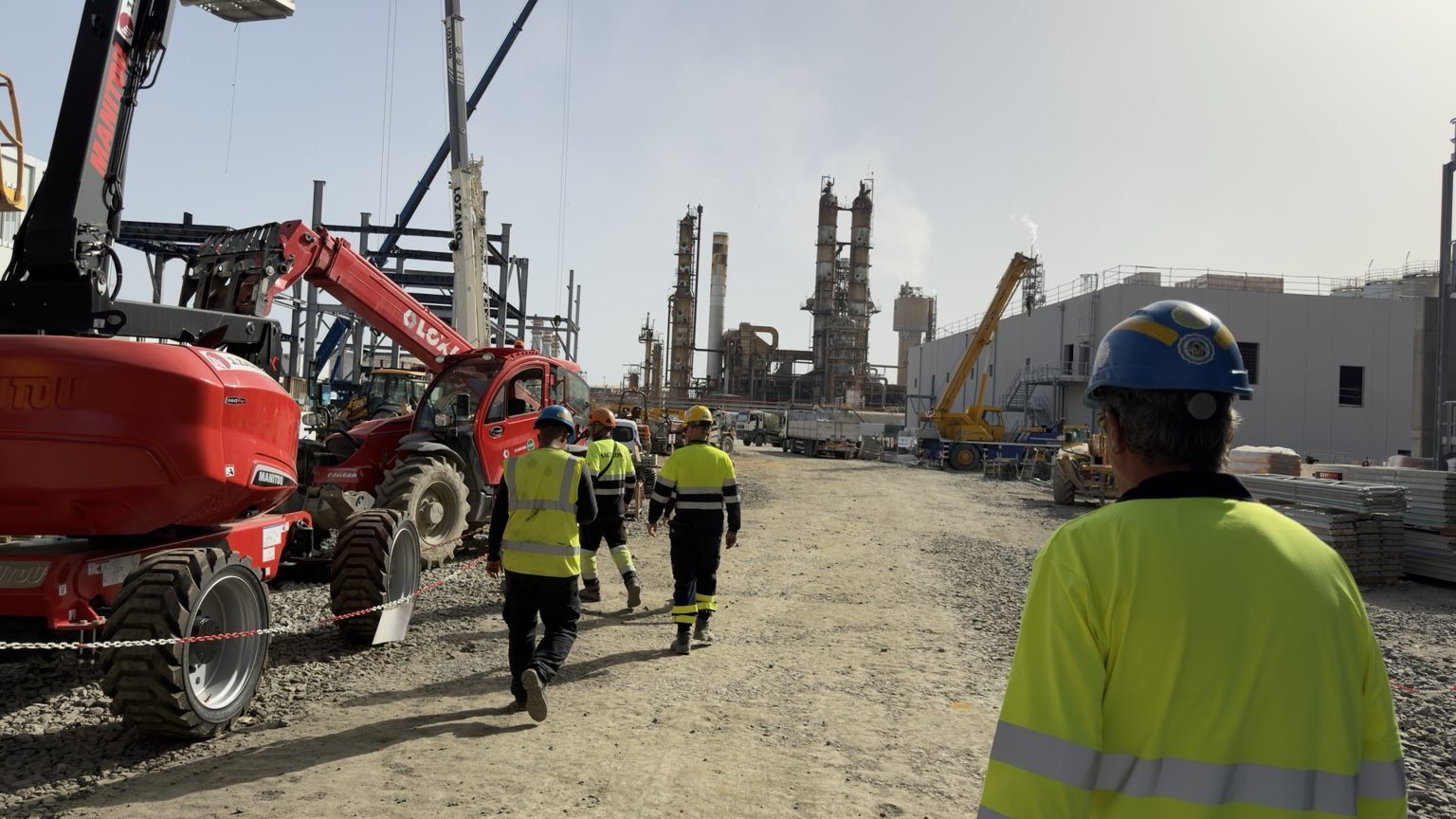 Equipa técnica com gruas em refinaria industrial